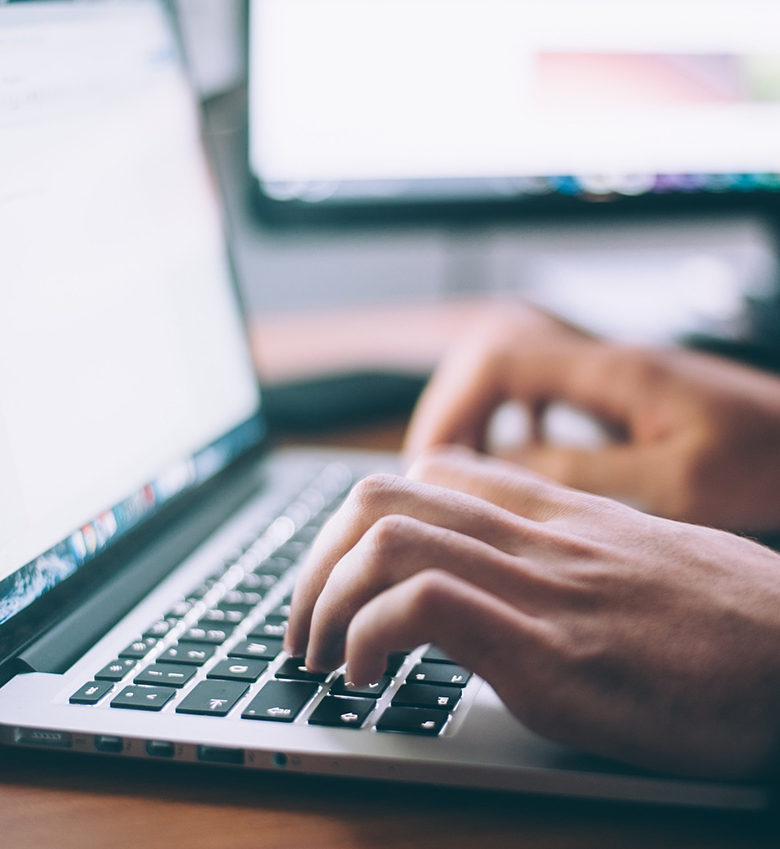 Mitarbeiter tippt auf Notebook-Tastatur